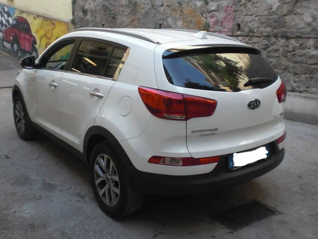 Automobile Kia Sportage bianca parcheggiata.