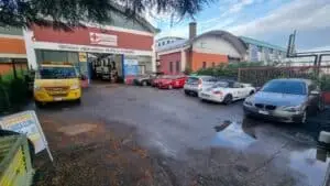 Officina riparazione veicoli e parcheggio esterno.