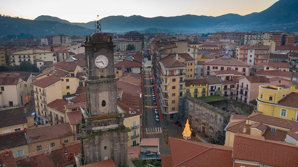 Veduta aerea di una città al tramonto con campanile.