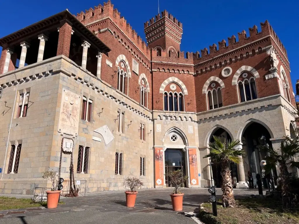 Palazzo in stile neogotico con torre e palme.