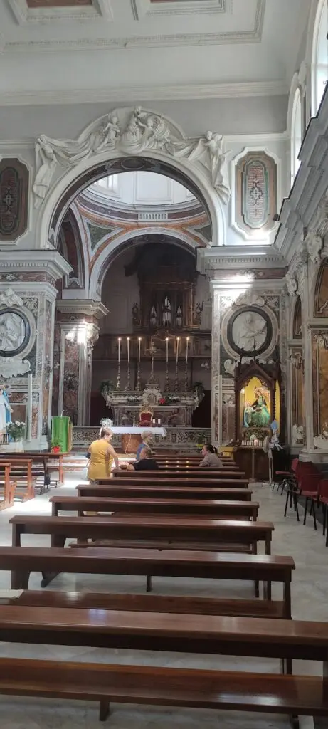 Chiesa barocca interna, fedeli in preghiera.