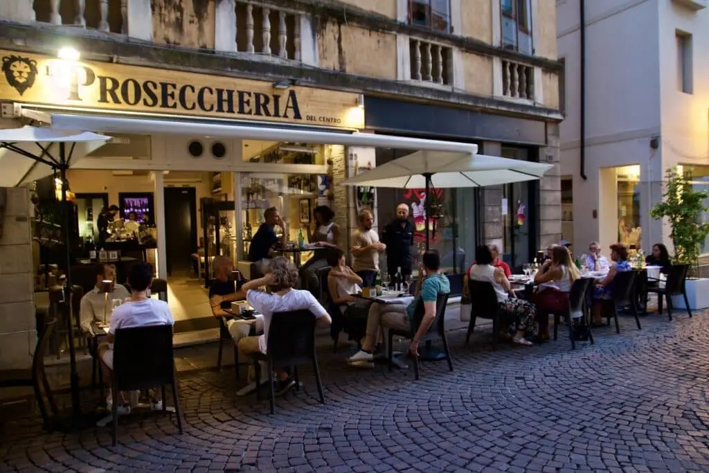 Terrazza estiva di Prosecceria affollata in serata.