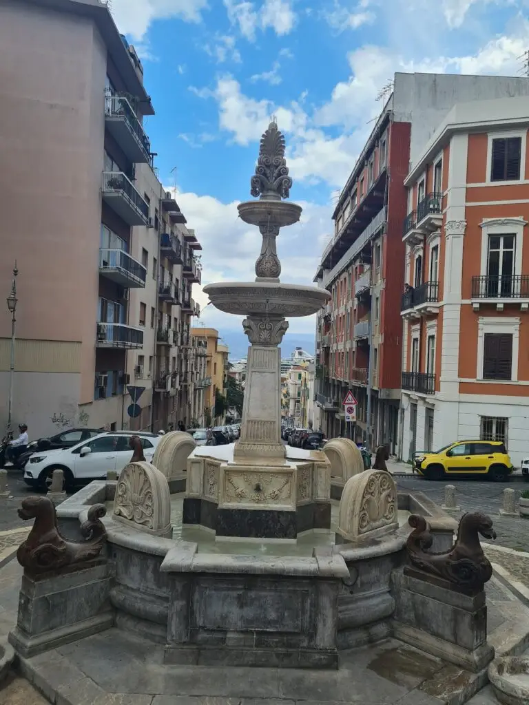 Fontana storica in strada cittadina italiana.