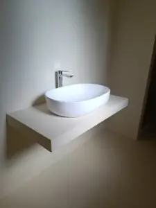 Lavabo sospeso moderno con rubinetto cromato e illuminazione indiretta.