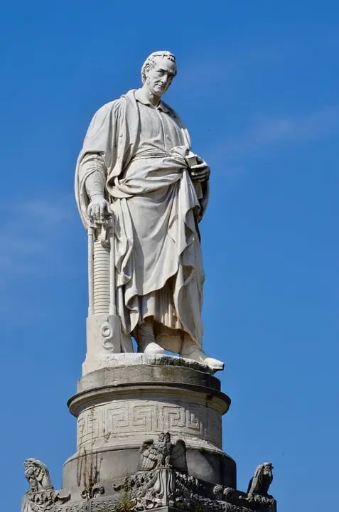 Statua marmorea di figura storica su colonna.