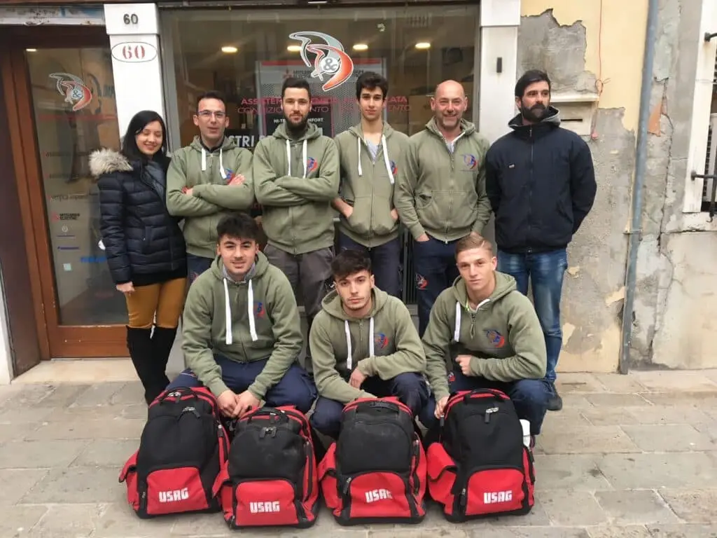 Gruppo di persone con abbigliamento sportivo e zaini.