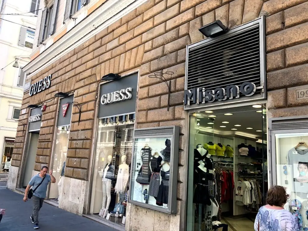 Negozio di abbigliamento Guess e persone in città.