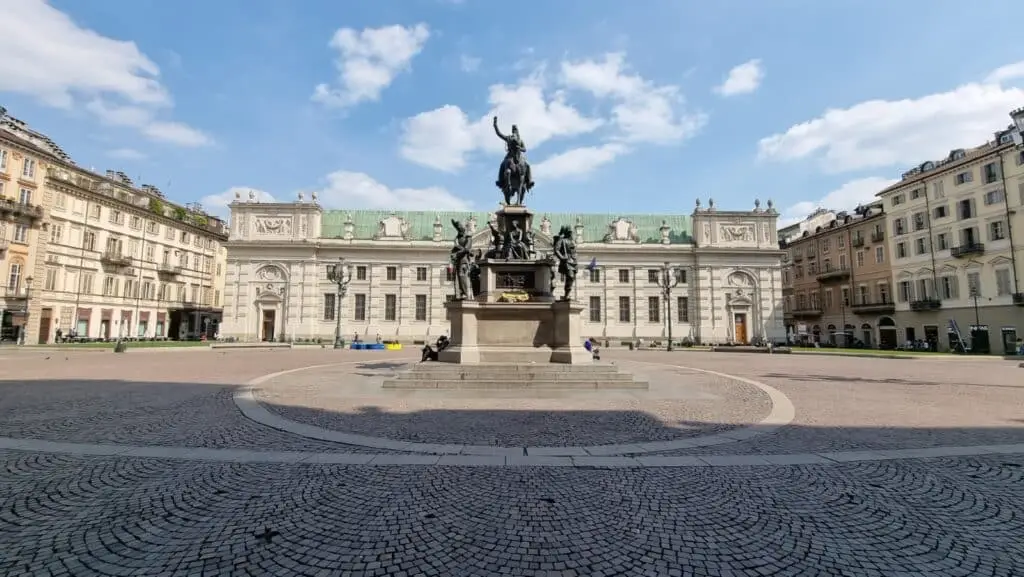 Piazza con monumento equestre e palazzi storici.