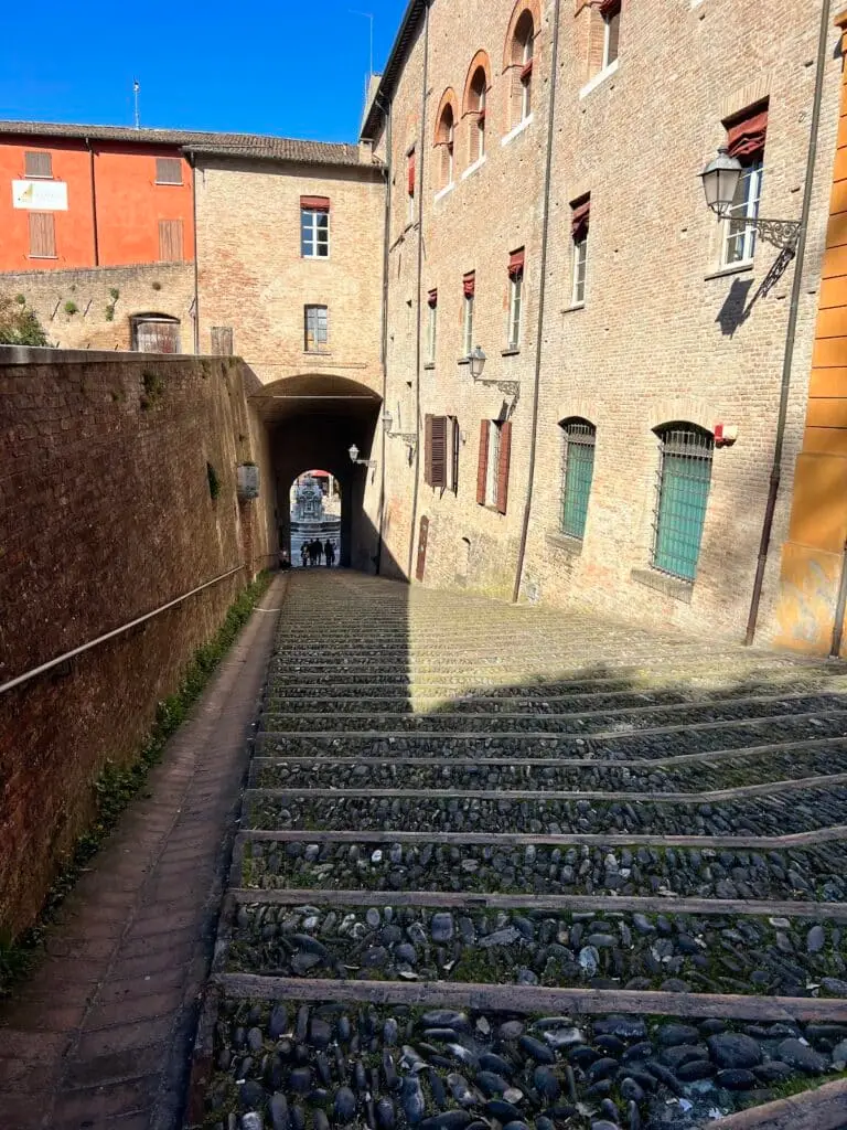 Vicolo storico italiano con pavimentazione in ciottoli.