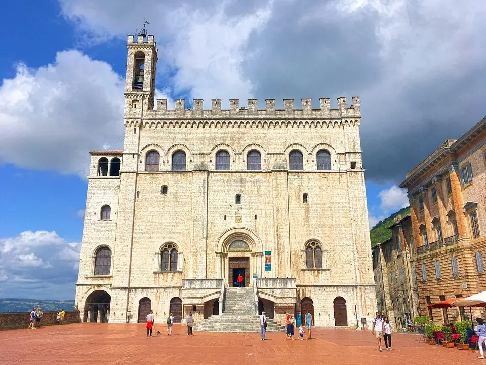 Palazzo storico italiano in piazza con turisti.