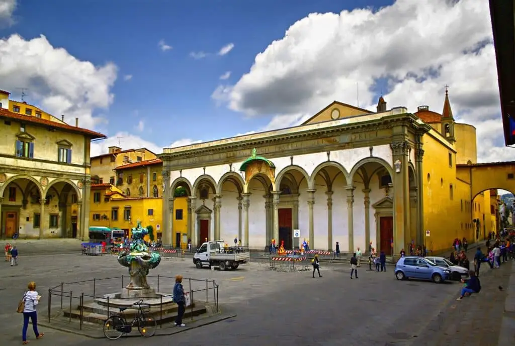 Piazza storica italiana con fontana e architettura.