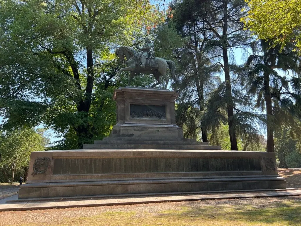 Statua equestre in parco alberato.